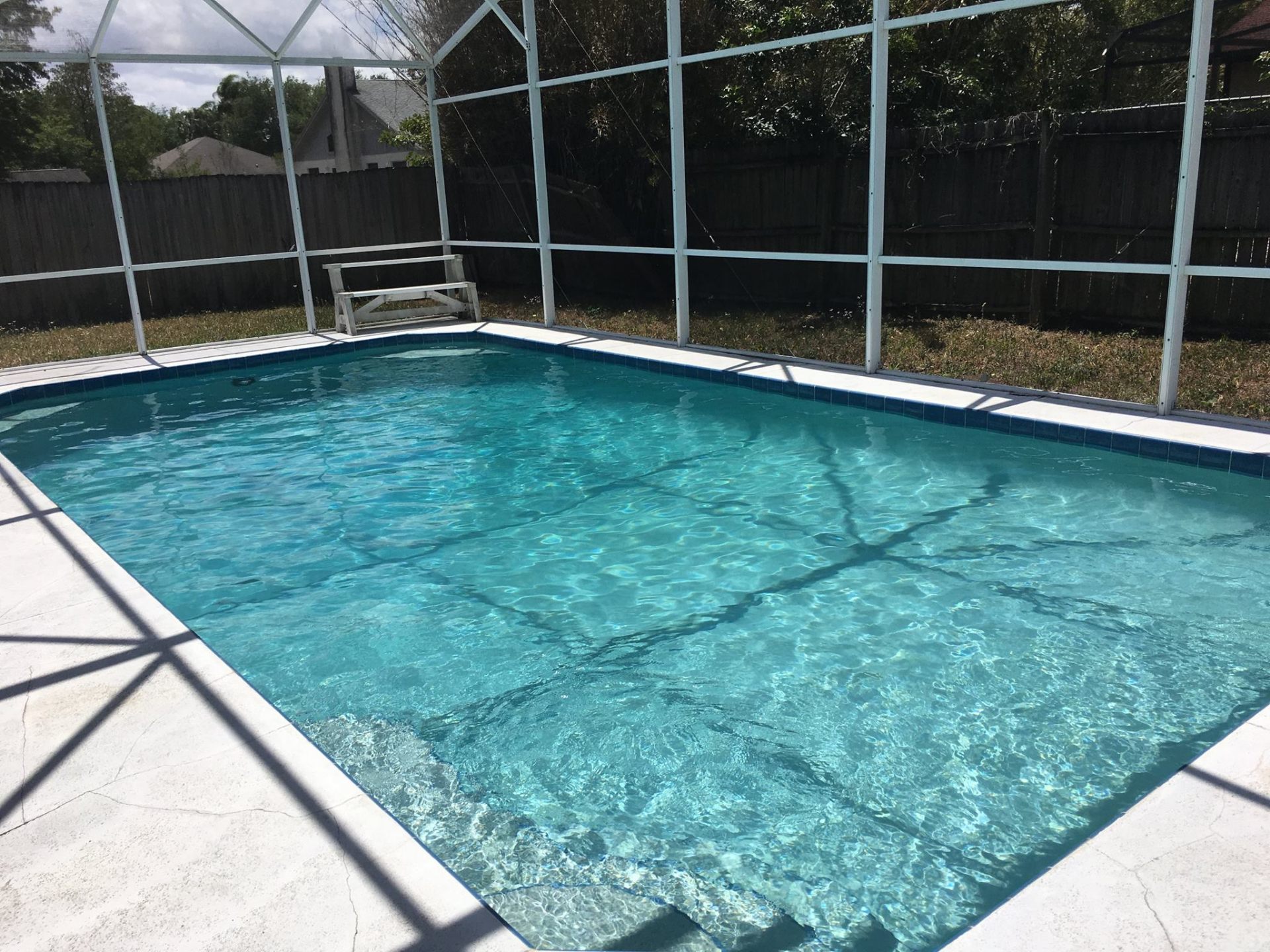 Crystal clear screened pool after Sunny Clean Pool weekly maintenance in Wedgefield, Florida