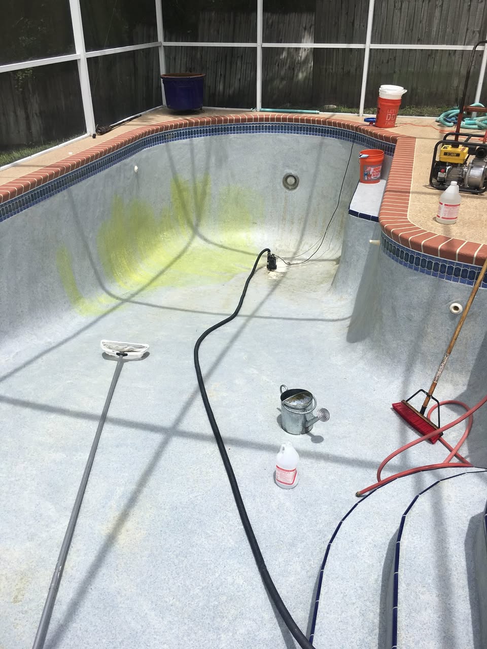 Drained Central Florida pool with heavy green algae staining being treated by Sunny Clean Pool